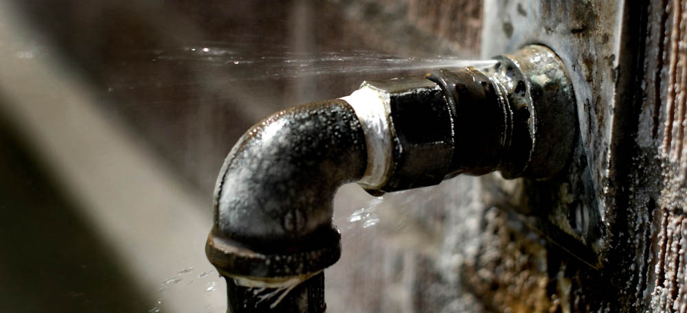 water gushing from burst pipe