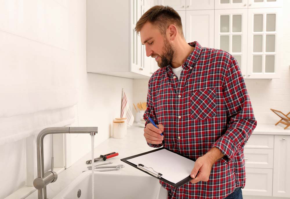 plumber holding a clipboard while doing an inspection plumber holding a clipboard while doing an inspection